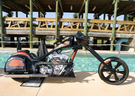 Black and orange coloured Chopper by pool in Florida